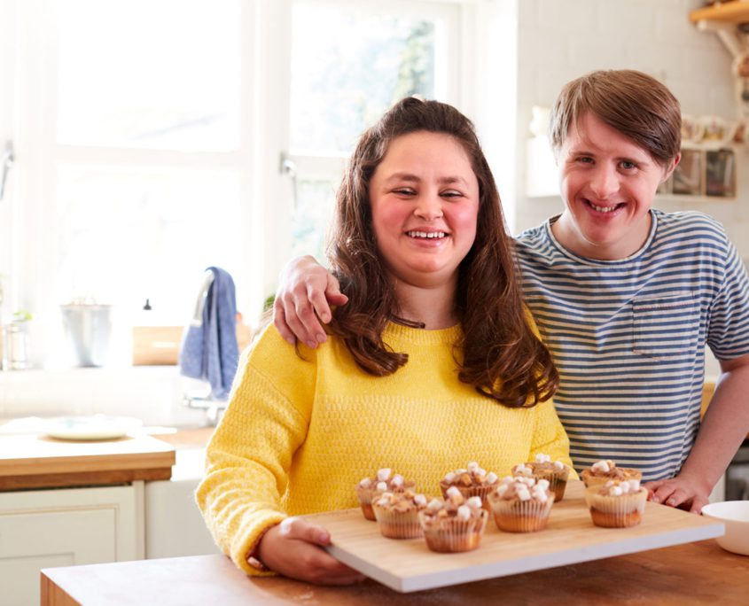 How Can Home Care Help Me - Portrait Of Downs Syndrome Couple Decorating Homemade Cupcakes